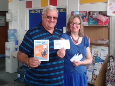 Secretary Lion Tony Parris, presenting a cheque for £540 towards transport costs to Liz, Treasurer of Mid Sussex Speak Up